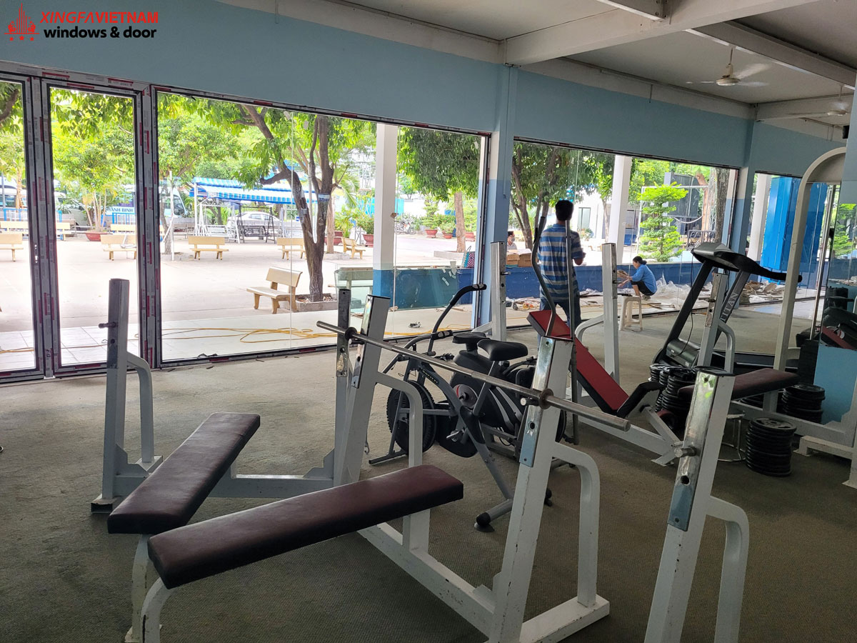 Lắp đặt cửa đi quay 2 cánh nhôm xingfa và vách kính cố định tại phòng gym trường Thanh Bình, quận Tân Bình